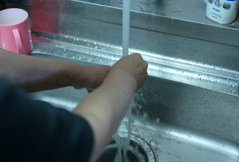 洗い物をする秋子さん