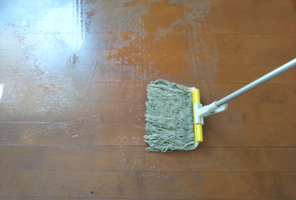 剥離剤をモップで塗り込む