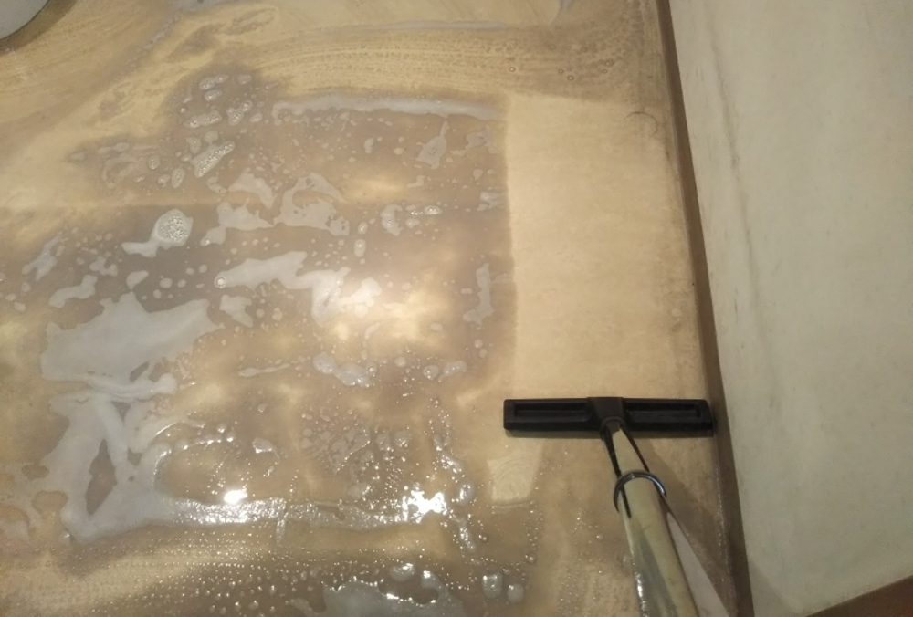 洗浄後の汚水をウェットバキュームで吸う