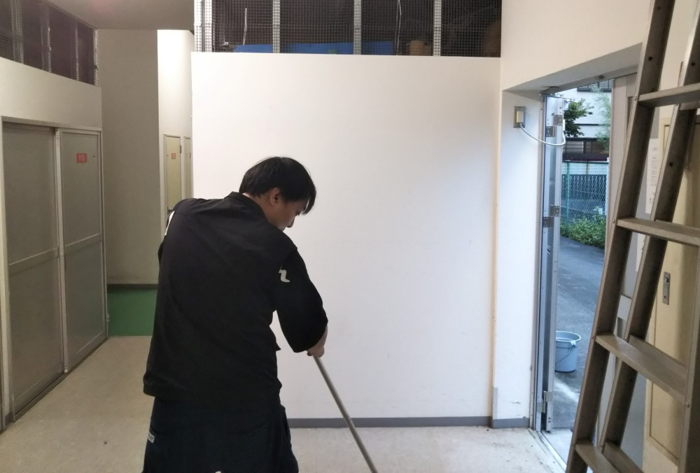 モップで床を拭く、後ろ姿の佐野直人