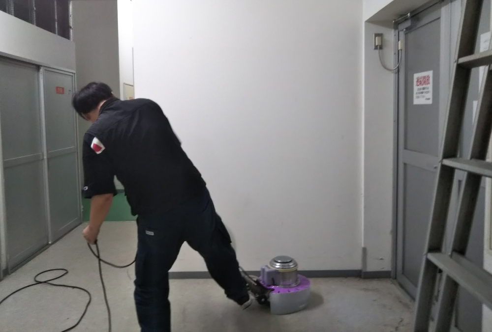 ポリッシャーハンドルを倒すため、ペダルに足をかける 佐野直人