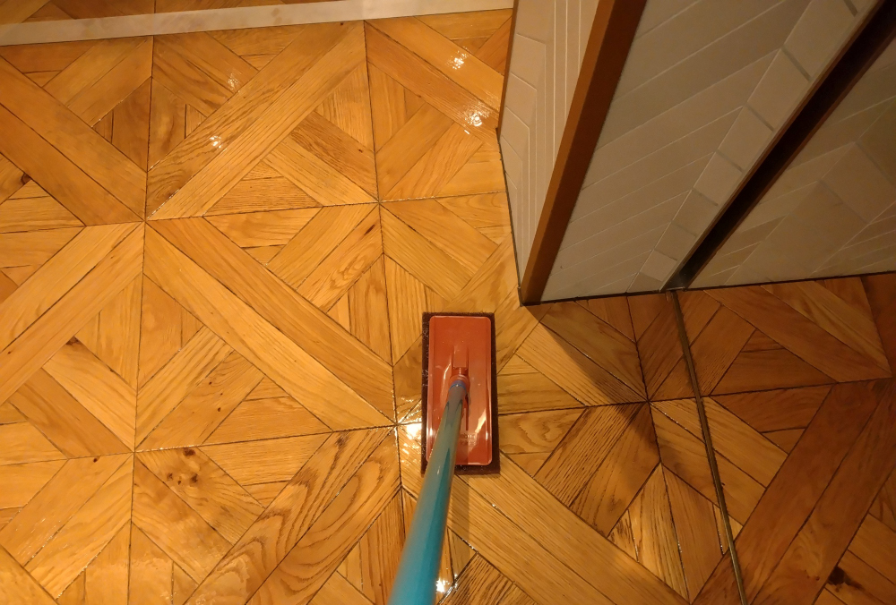 剥離剤を浸透させ、茶パット付きパットホルダーで表面を擦る