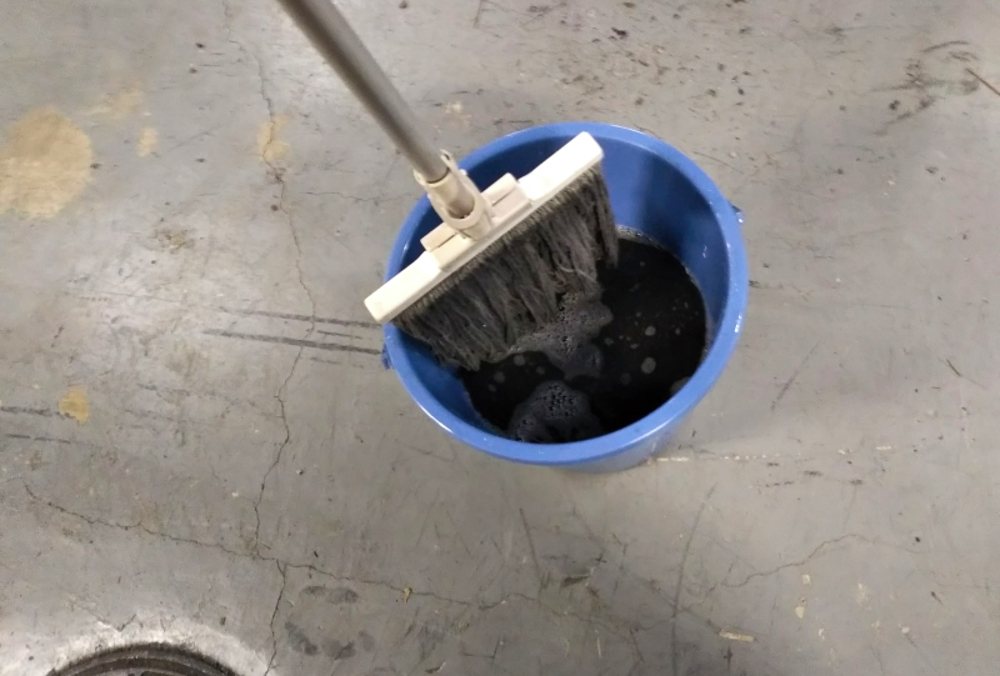 バケツの水でモップを濯ぐ