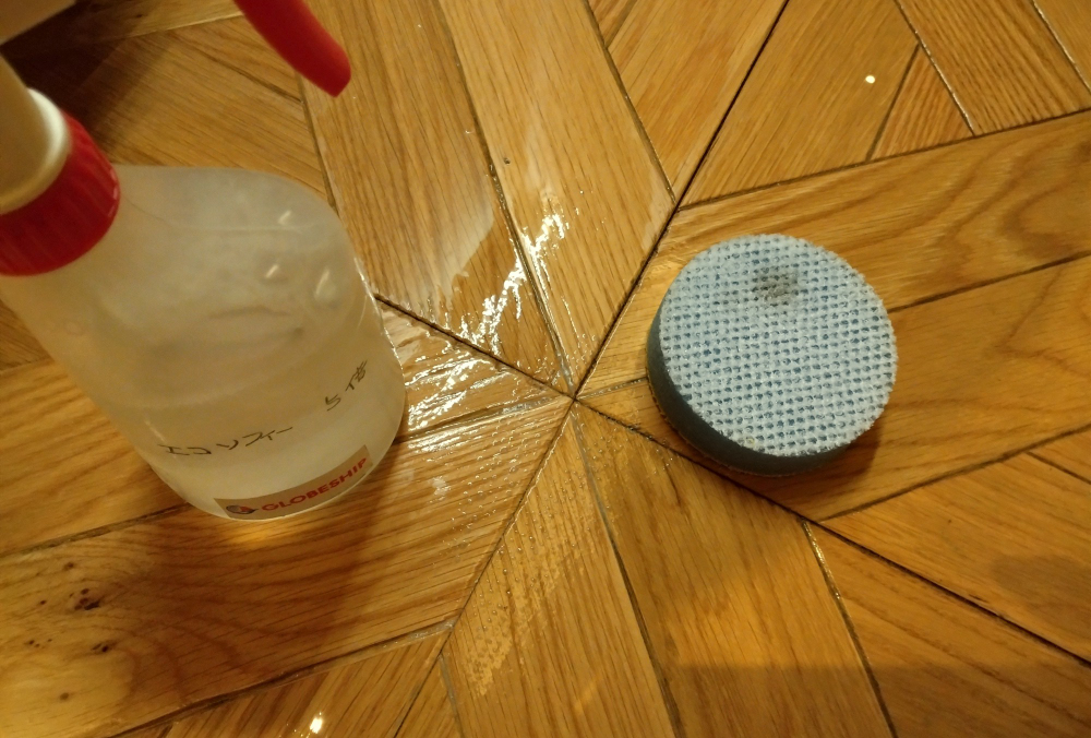 洗剤入り噴霧器とパットでかがんで擦る